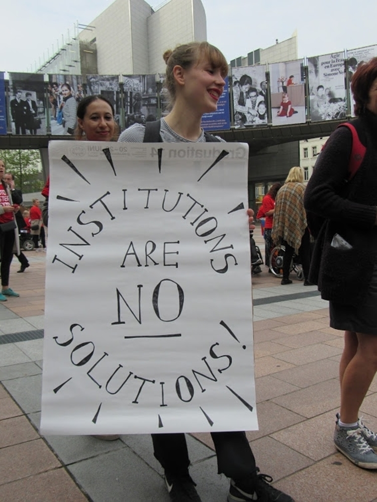 Vrouw met poster: Institutions are no solutions
