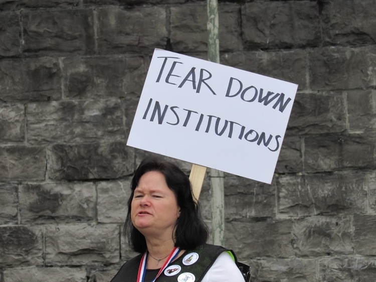 vrouw met bord: tear down institutions