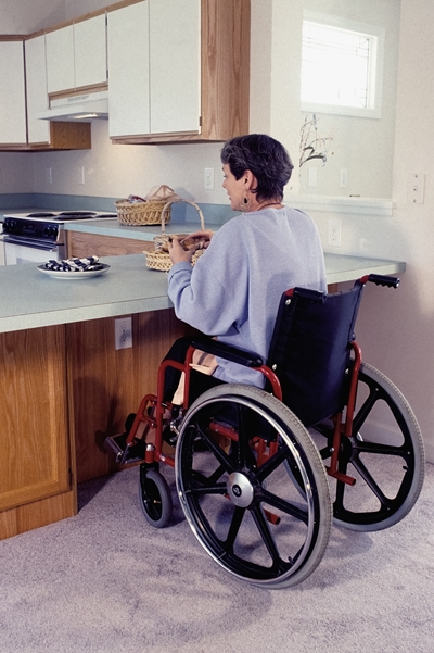 Vrouw in rolstoel in een aangepaste keuken