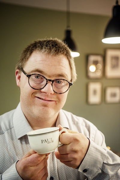 Paul Pasteels in zijn keuken met een koffietas